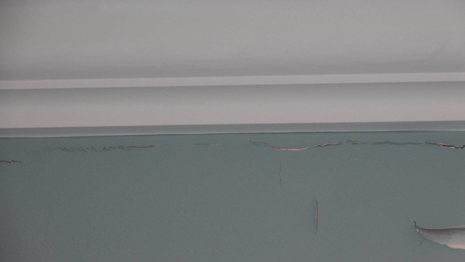 Continuous horizontal crack beneath the crown moulding