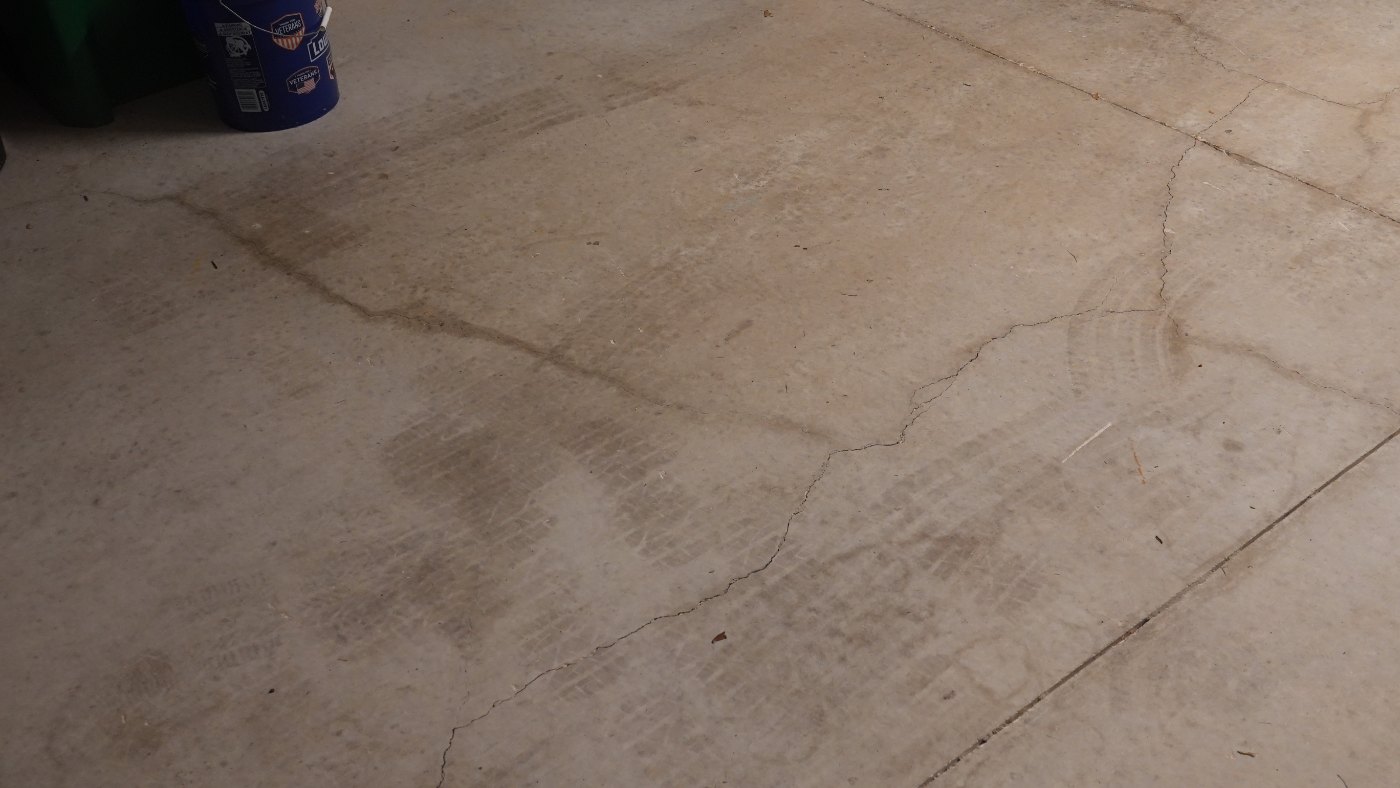 Garage slab, wide view: long crack running across the slab to the control joint